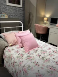 Nowocześnie urządzony pokój nastolatki z neutralnymi meblami, kolorowymi dodatkami i lampkami LED – przestrzeń do wyrażania siebie